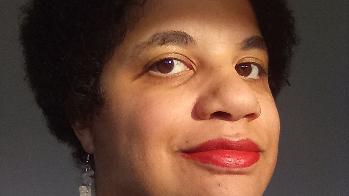 A brown-skinned woman wearing red lipstick